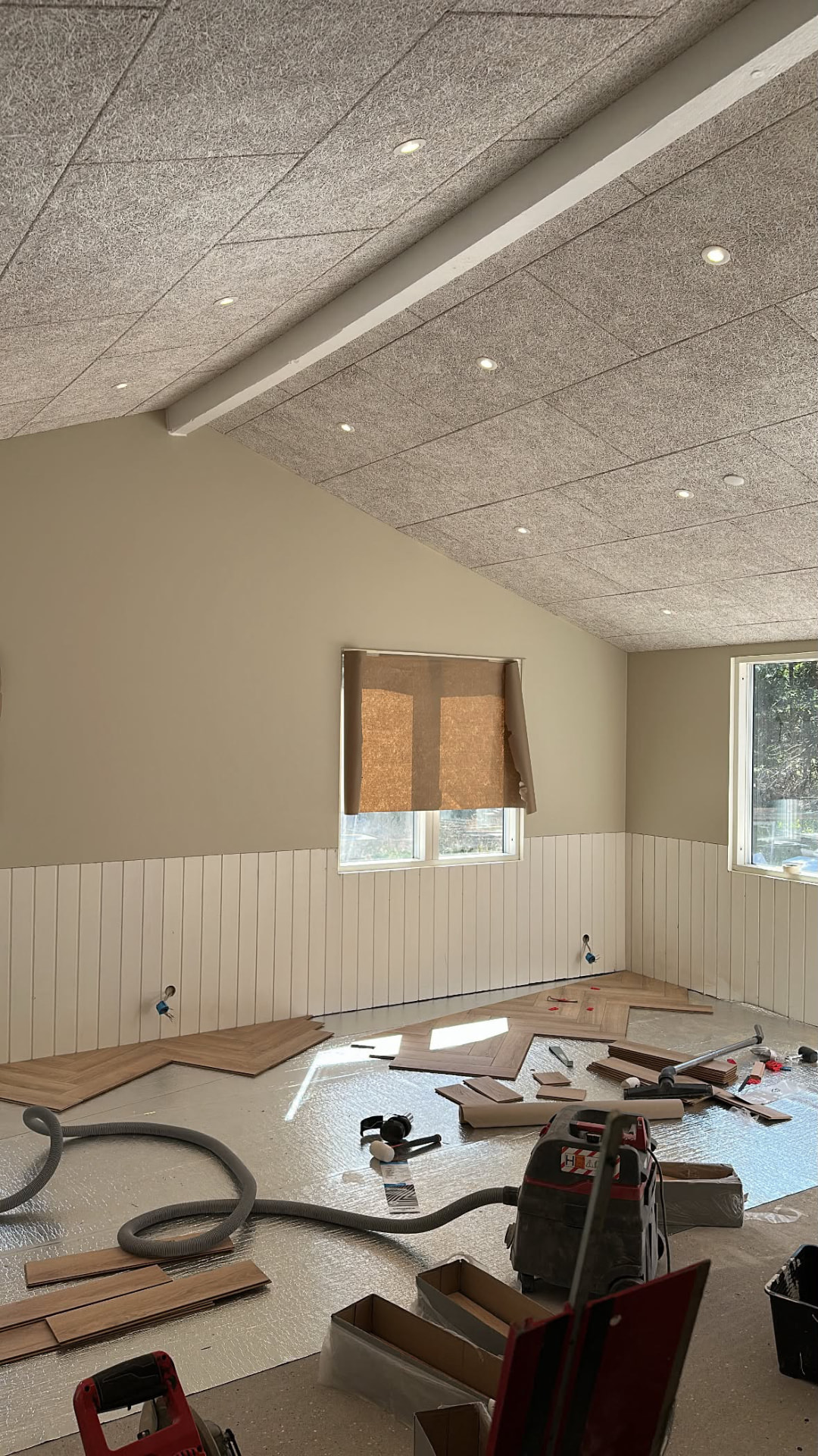 Værelse under renovering hos Malerfirma Gashi: nymalede træpaneler, akustisk loft med spots og nyt trægulv under opsætning